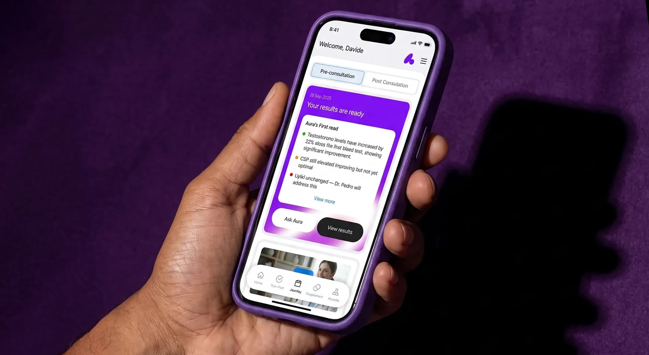 Hand holding a phone showing the nuAura app, with a card announcing that the blood test results are ready